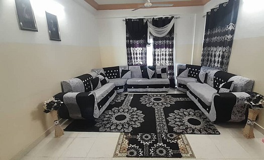 Salon en bon état avec rideaux et moquettes