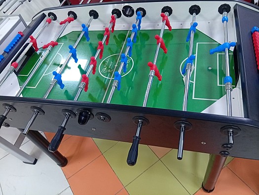 Baby-foot professionnel, terrain vert, joueurs rouges vs bleus